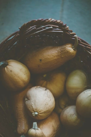 A bunch of yellow ripe bottle gourds in a woven basket 