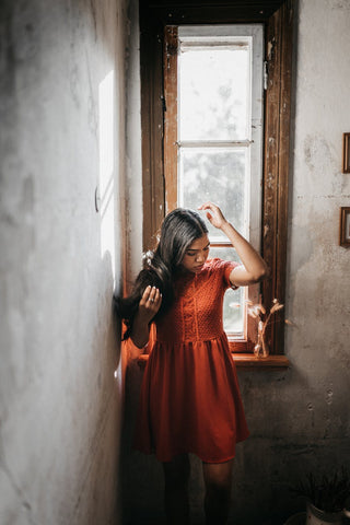 Woman in a red dress holding her hair 