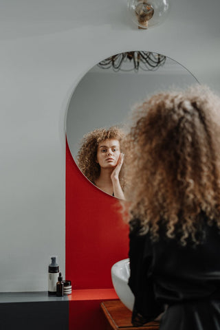 Woman with curly hair looking in the mirror