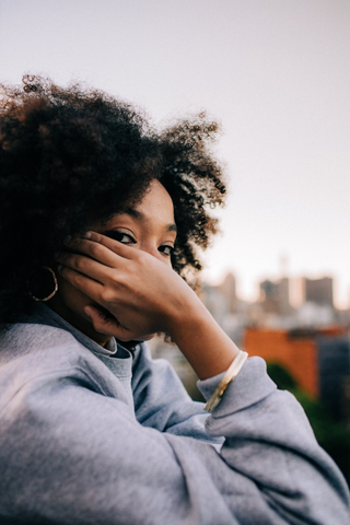 woman with high volume hair covering her face 