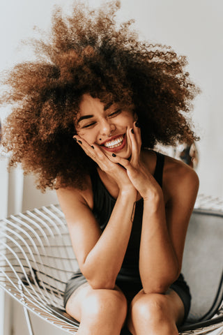 A smiling woman sitting in a chair 