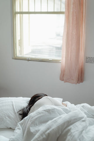 Woman sleeping under a white blanket 