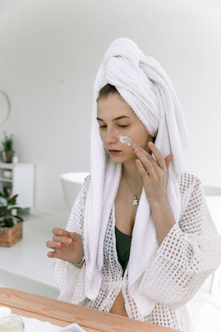 Woman applying moisturizer after taking a shower