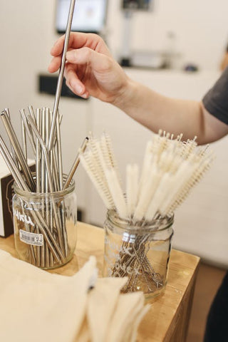 Hand picking out a stainless steel straw 