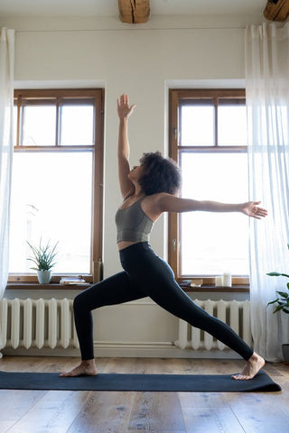 A woman standing on a mat doing a standing yoga pose