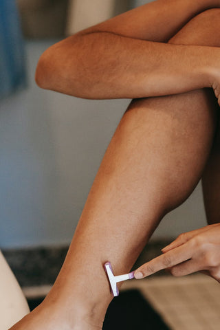 Woman shaving her hairy legs 