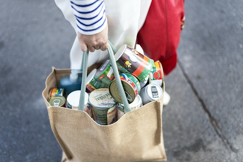 Hand holding a bag full of grocery items 