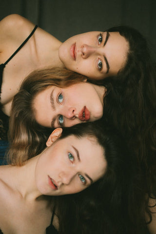 A group of 3 women with long hair 