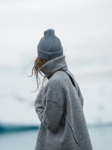 Woman in fully winter clothes looking at glaciers 