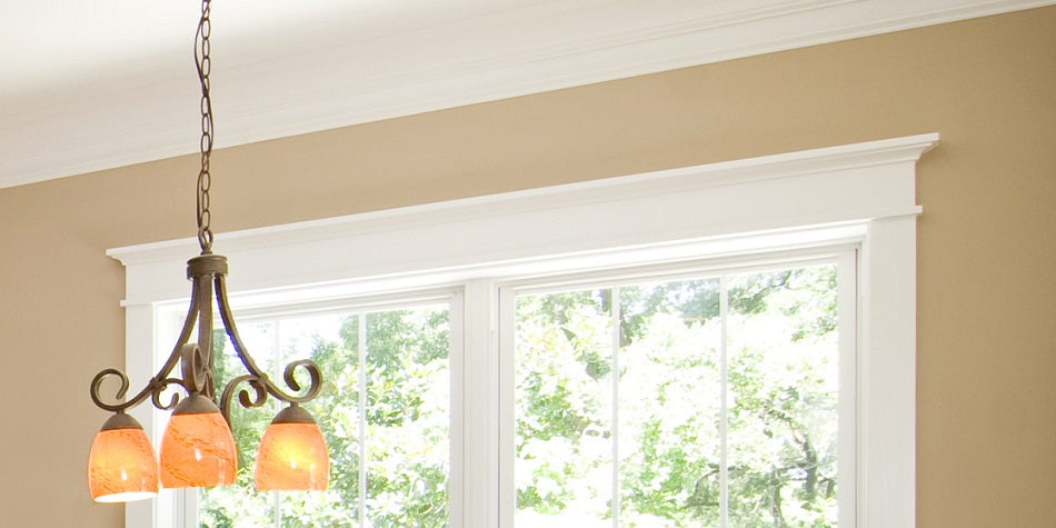 window with crown molding and hanging lamp