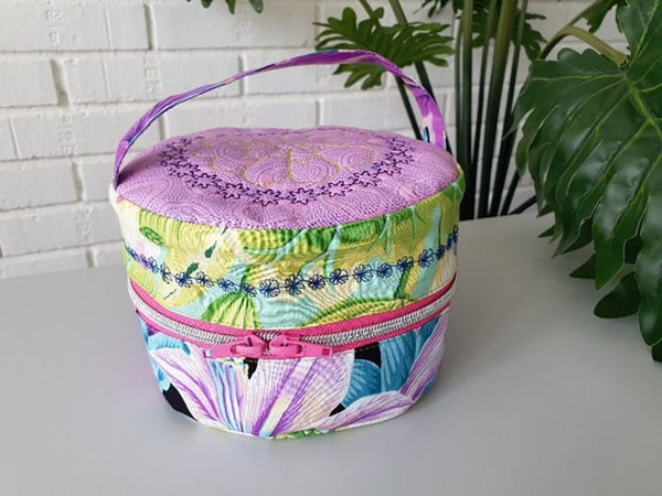 Kaffe Fasset Colorful Round Zipper Bag shown with floral embroidered embellishments on a gray table