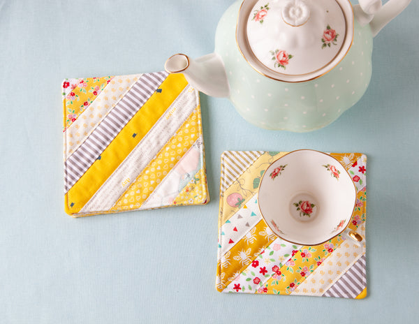 BERNINA Scrappy Coasters in yellow and cream on a table with mugs