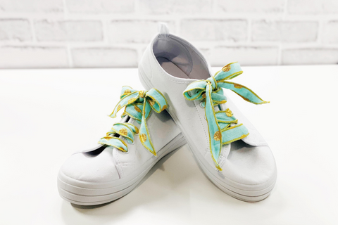 two white sneakers with handmade shoelaces