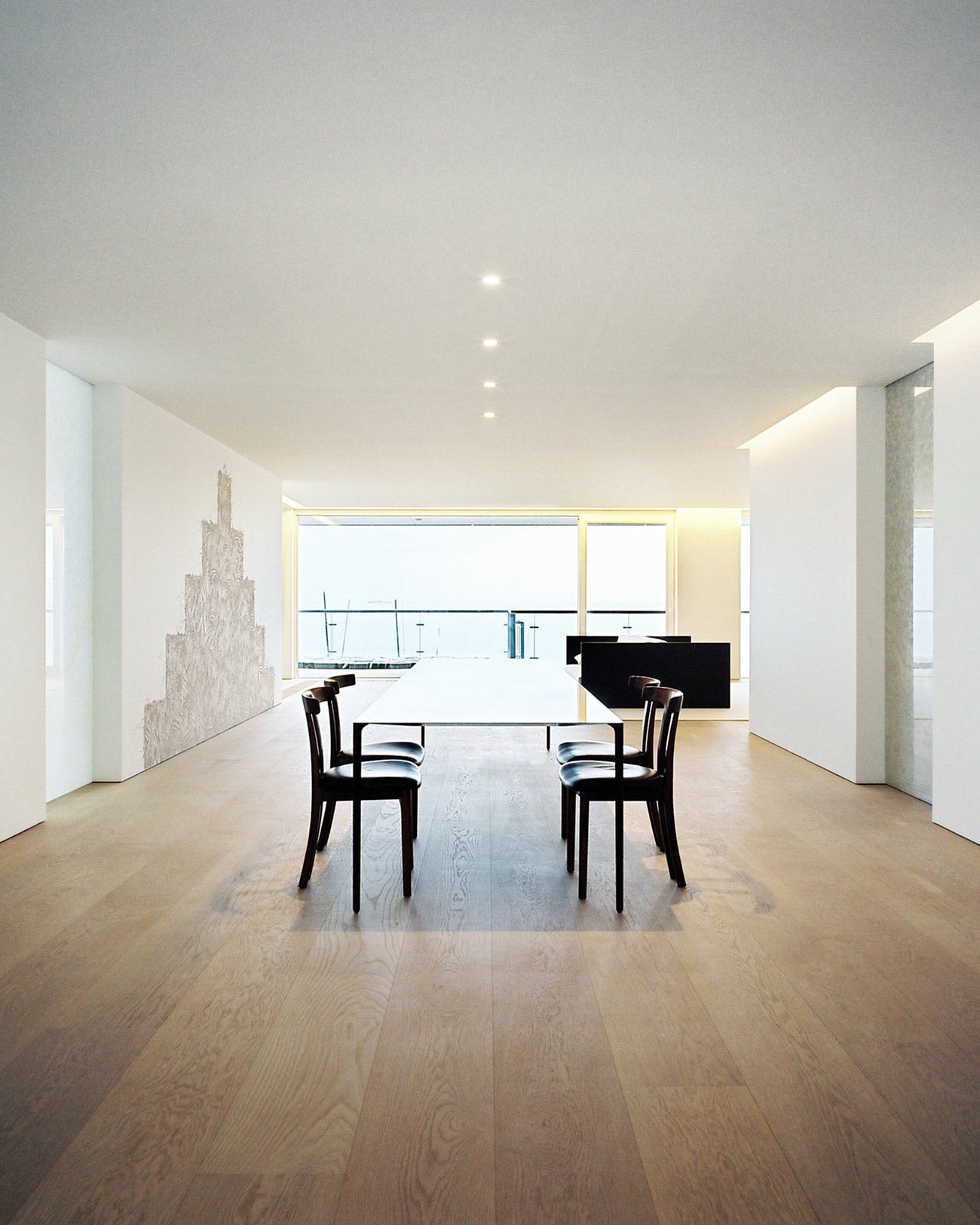 North Sea Apartment de Pawson, interior minimalista con vistas al mar y continuidad de materiales naturales.