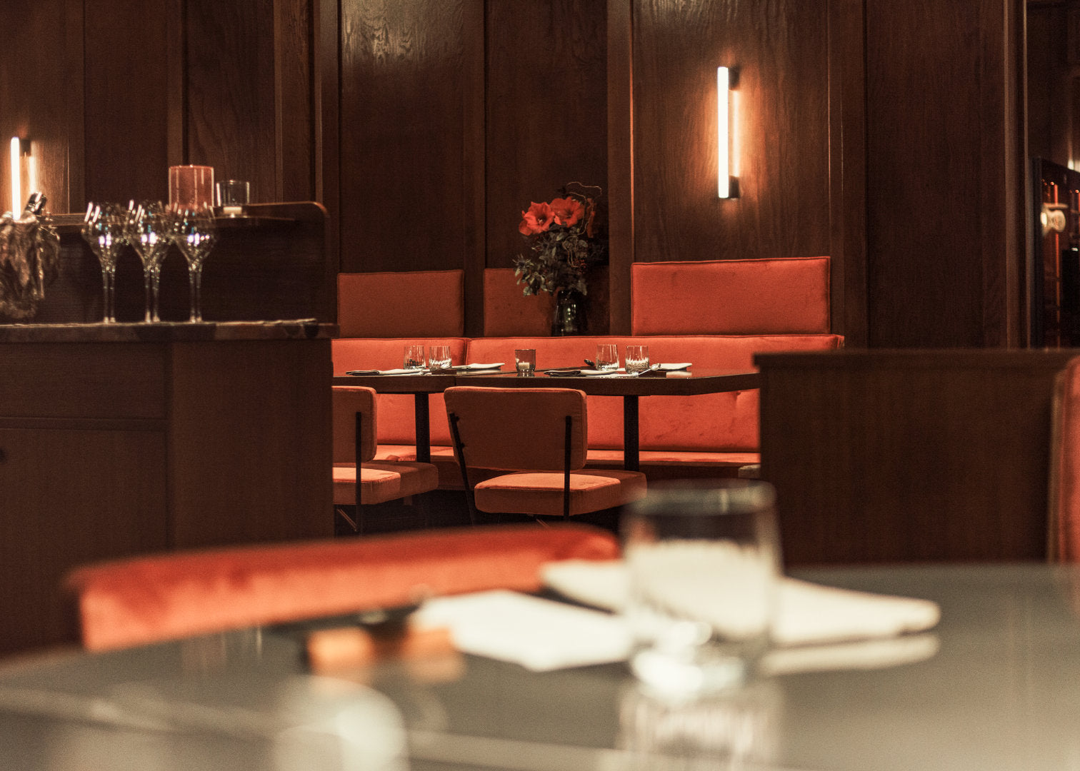 Innenansicht des Restaurant Jacobi mit holzverkleideten Wänden, samtig-orangenen Sitzmöbeln und Tischen aus Vulkanstein.
