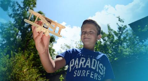 enfant qui joue avec une maquette en bois d'avion rokr et rolife