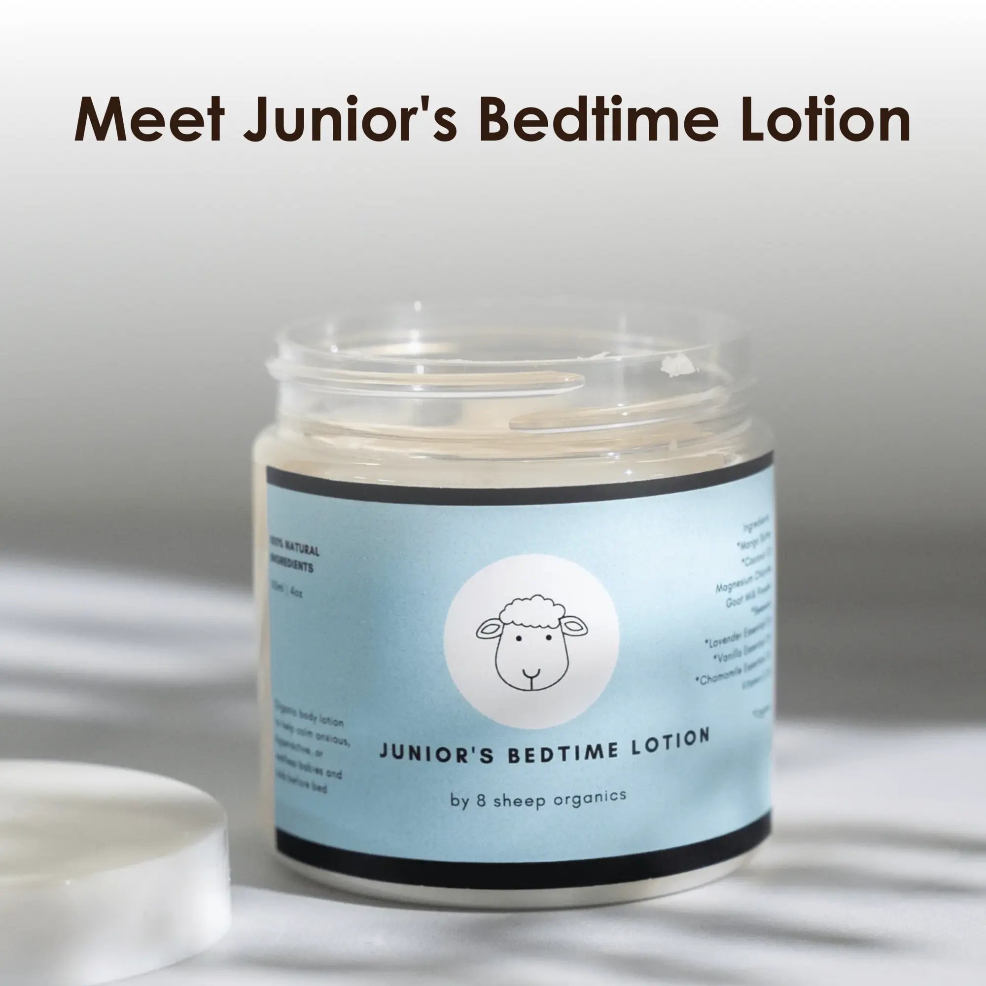 Jar of Junior's Bedtime Lotion by 8 Sheep Organics with a sheep logo and an open lid.