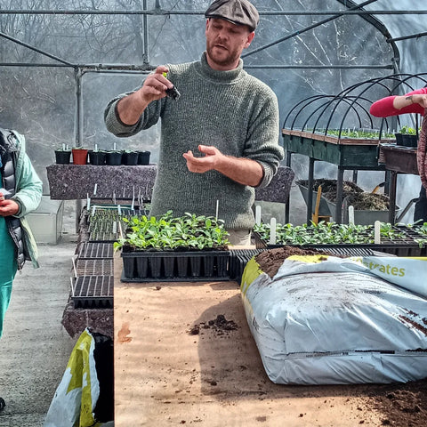 Tristan showing how to pot on seedlings