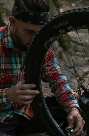 Mann schraubt an Fahrrad im Wald