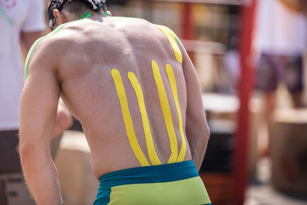 athlete wearing kinesiology tape on his lower back 