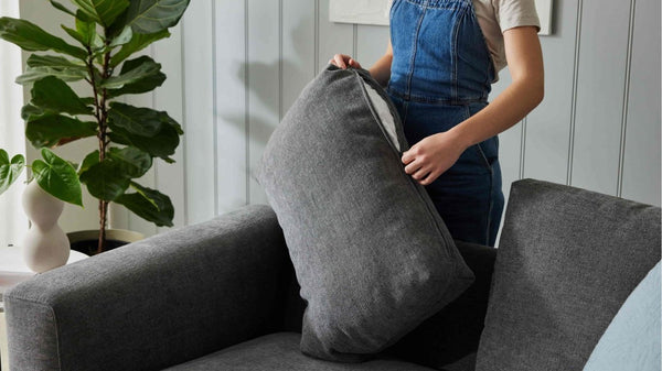 Women removing washable cover of her sofa