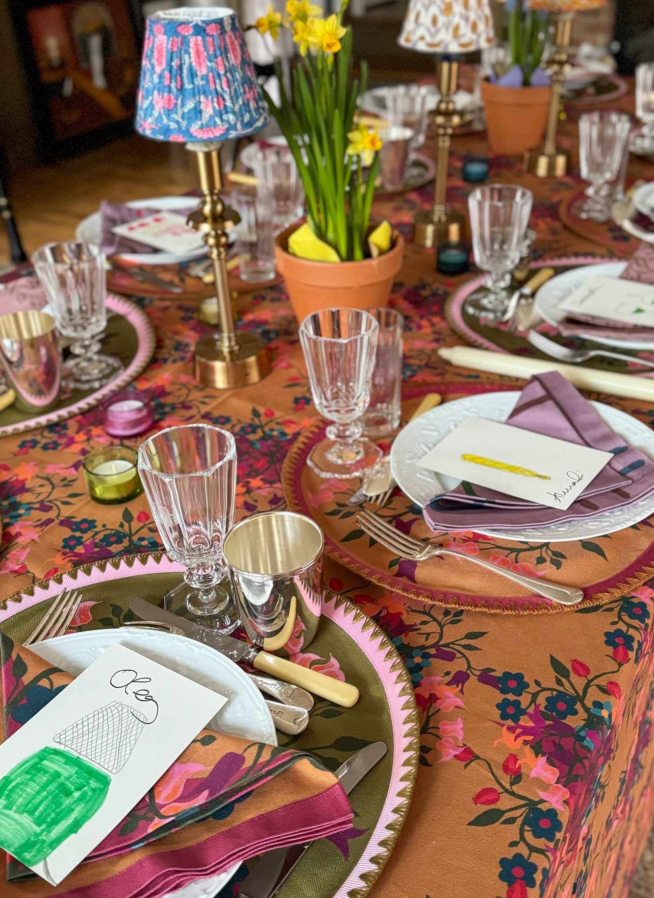 A floral colorful table set for a dinner party with seating arrangements.