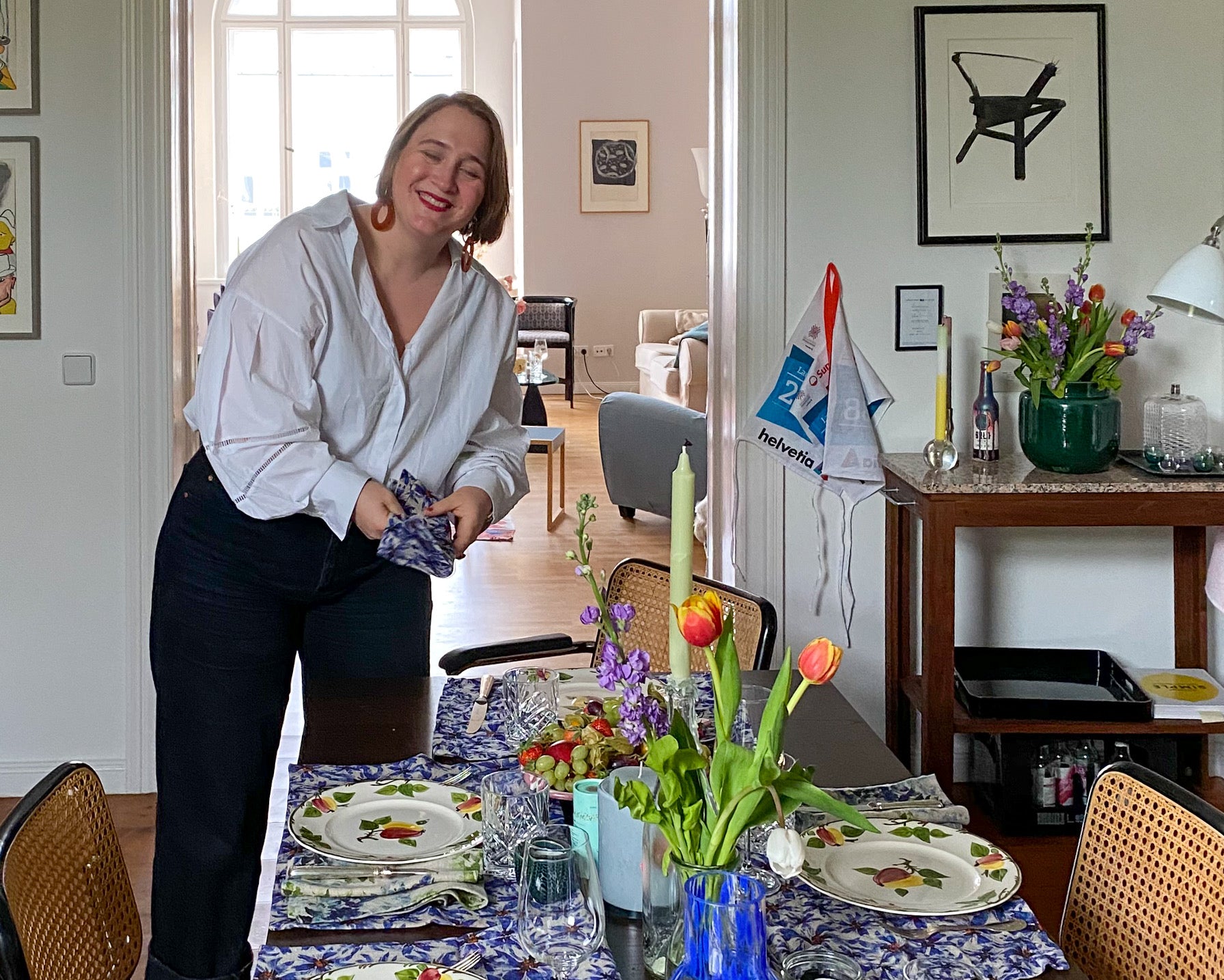 Sophie Williamson Design-Gründerin Sophie von Oertzen deckt einen Tisch mit ihren blauen Tischsets und Servietten aus Bio-Leinen.