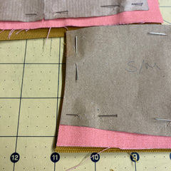 Cap fabric panels and cap patterns pinned to fabric