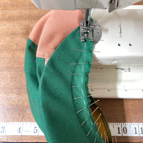 Panel cap peak being sewn to panel cap crown