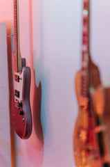 A wall with two guitars hanging from it. 