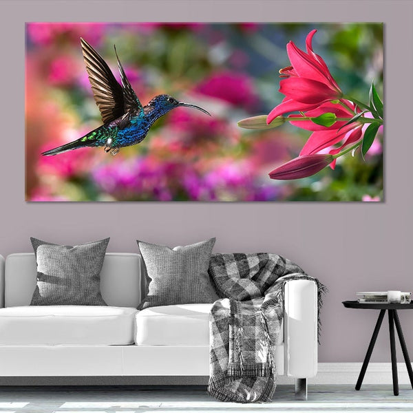 A canvas print of a humming bird approaching a pink flower. 