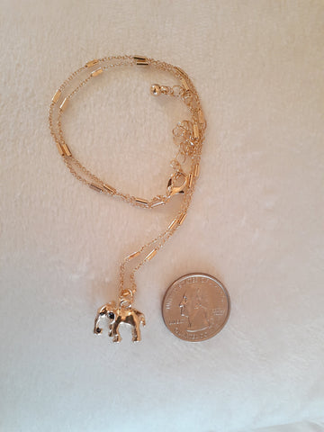 elefootprints-elephant-necklace-gold-comparing-size-to-a-quarter