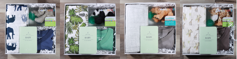 Side by side images of the Bundle of Joy baby gift boxes available at Doromania. Four boxes shown, each with a swaddle, a baby onesie, a pacifier plushie, and a baby journal.