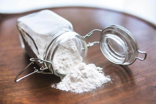 white powder pouring out of a clear jar close up view