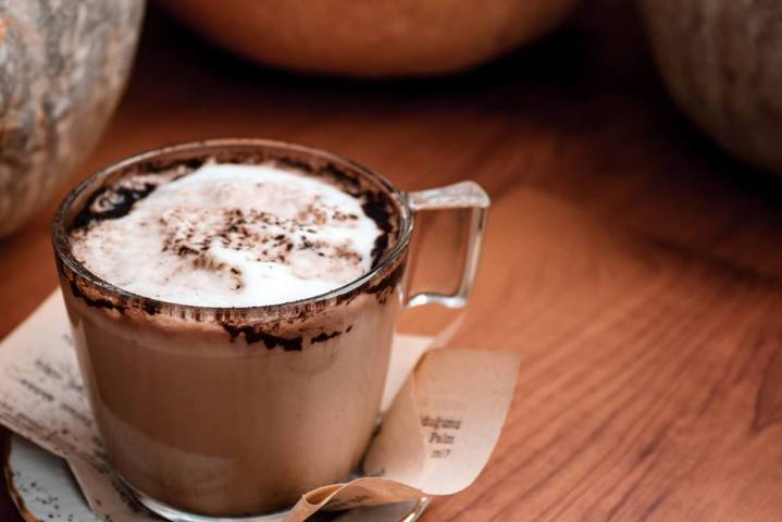 clear mug of chocolate drink with white froth