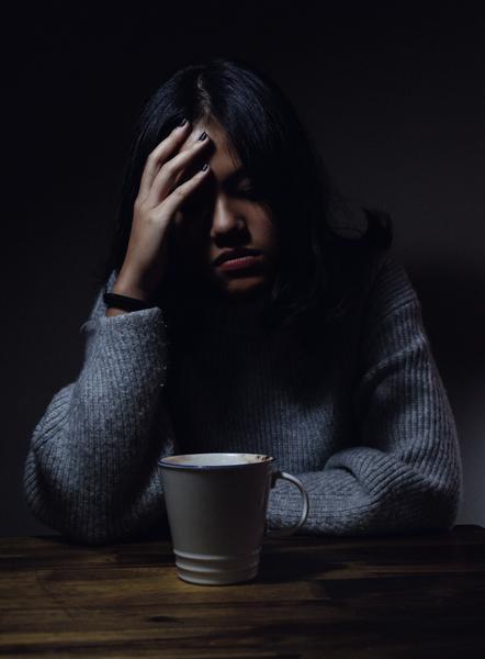 woman looking not too well with cup in front of her