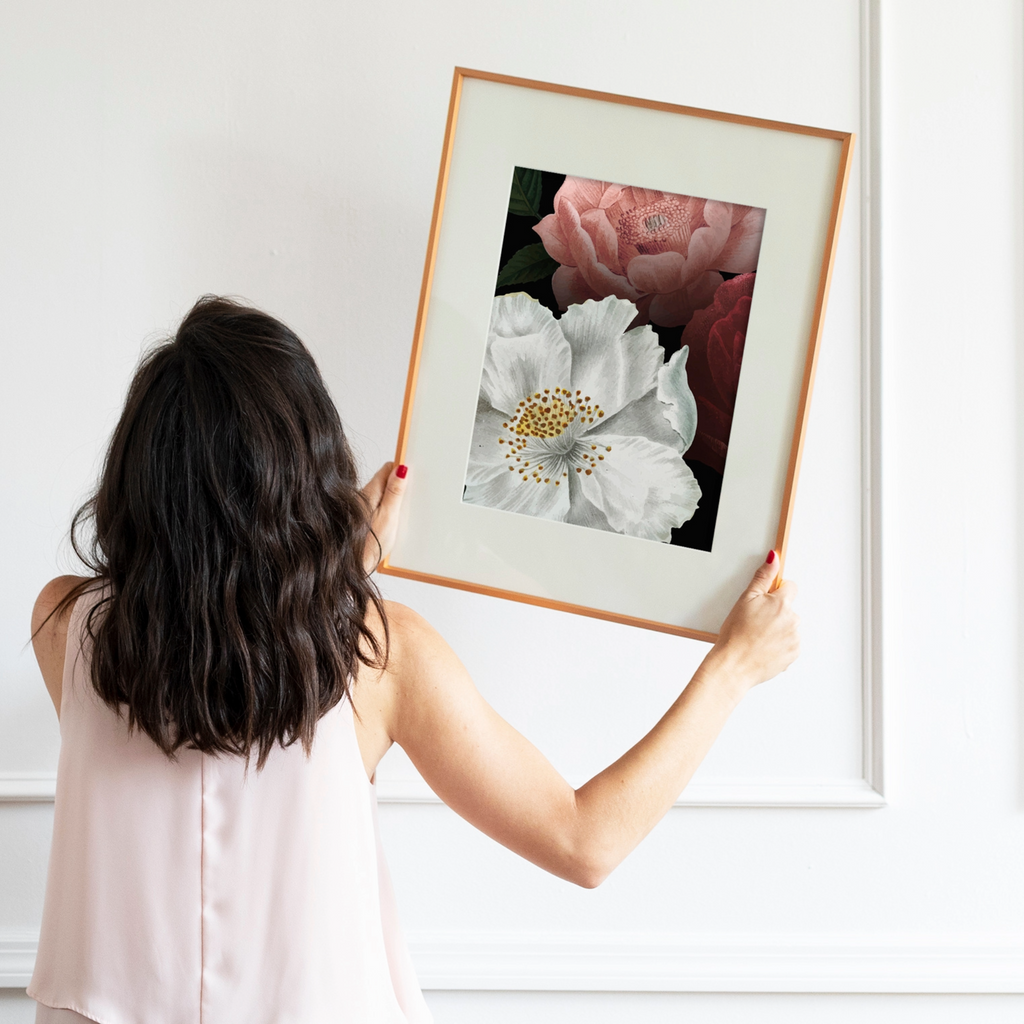 a women hanging a framed floral design wall art print