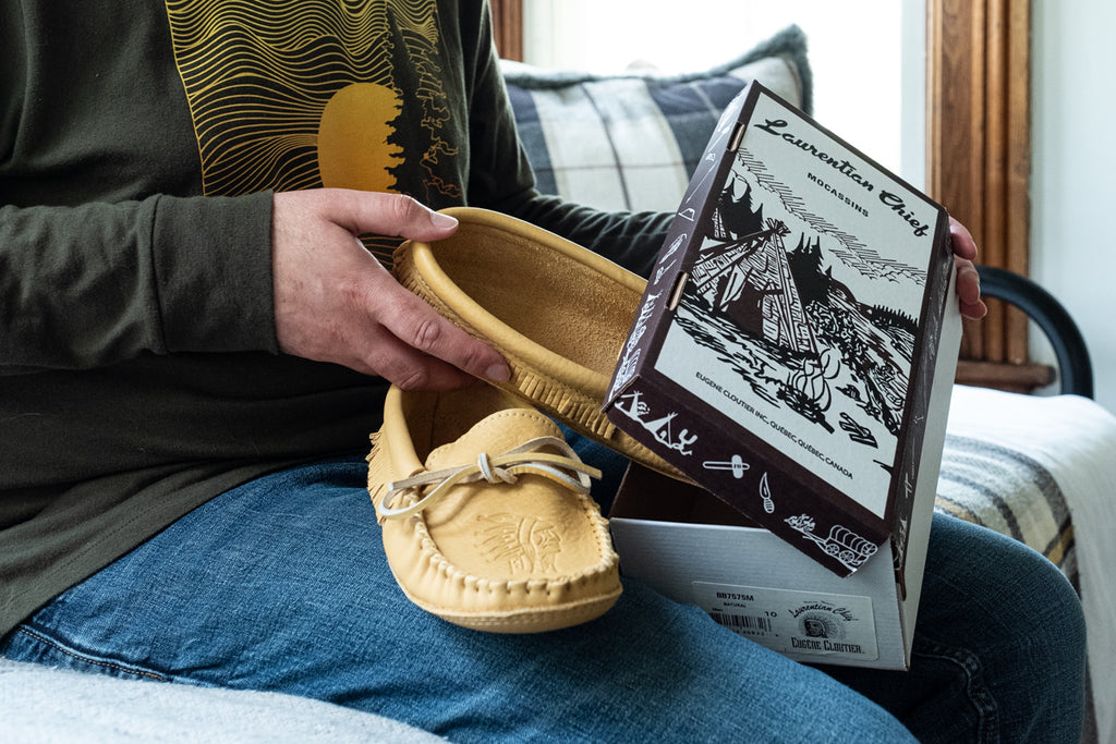 opening a box of men's Laurentian Chief Canadian moccasins