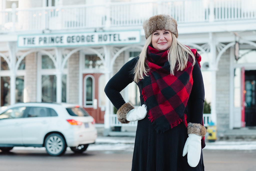 woman standing outside the prince george hotel in canada wearing buffalo plaid and rabbit fur headband