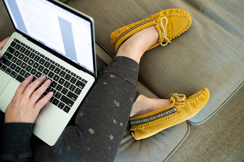 Working remotely on a comfortable sofa with Native moccasin slippers