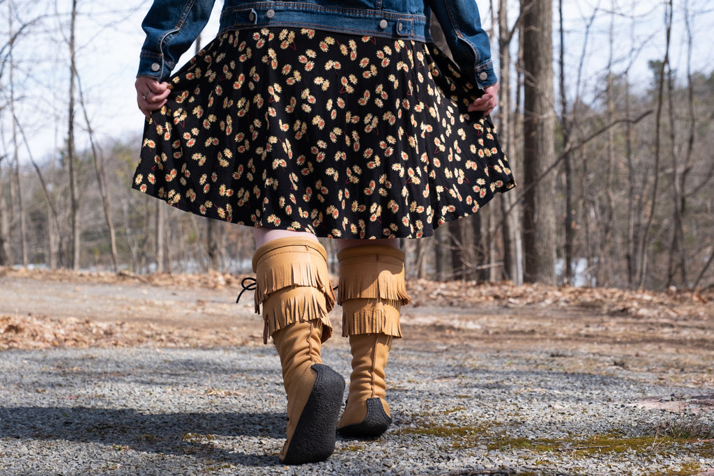 woman wearing stylish fringed knee-high moccasin boots