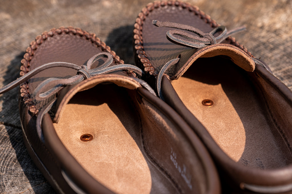 a pair of moccasins with copper rivet in sole for earthing grounding