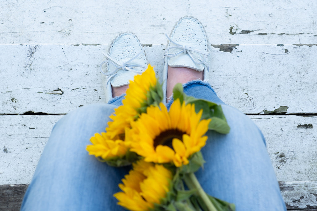 Bright yellow sun flowers and gorgeous white moccasin slippers