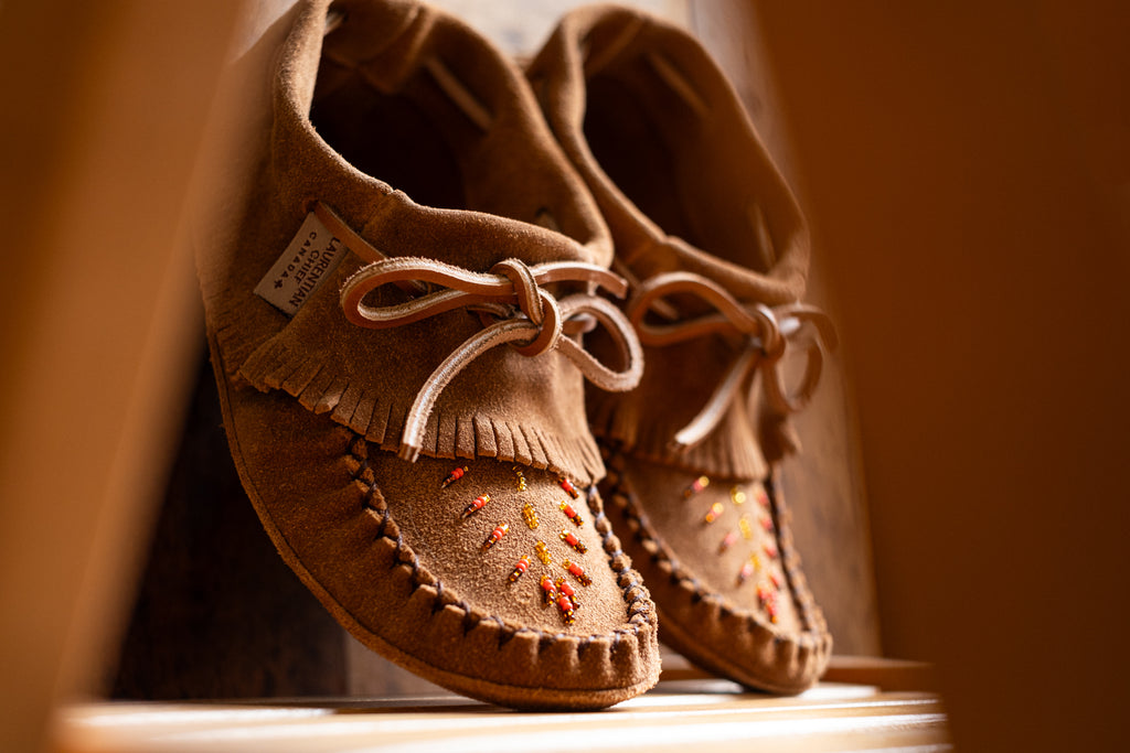 Beautiful authentic-looking fringed moccasin slippers ankle height with stylish beaded design on the vamp.