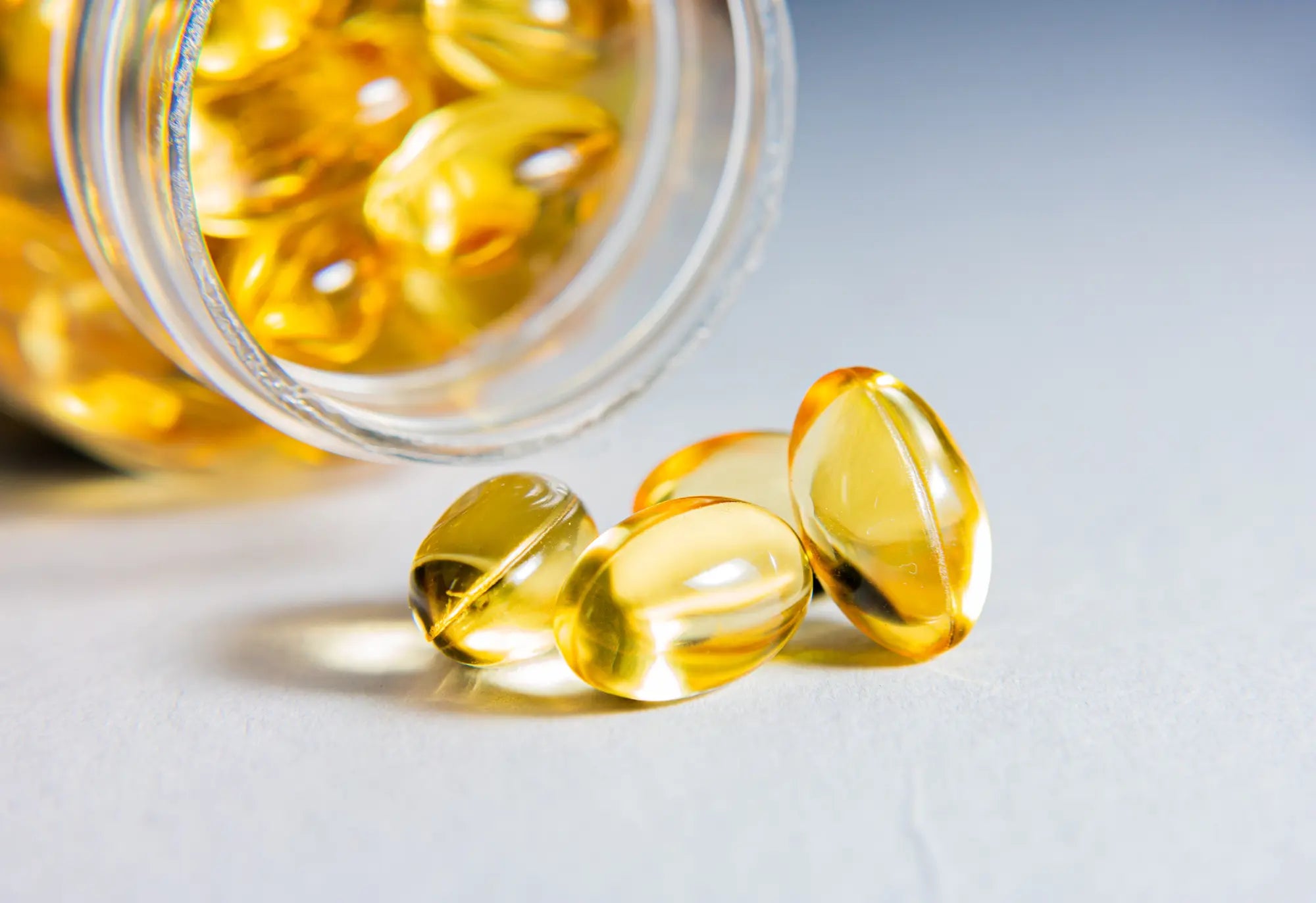 suplementos dorados que caen del tarro a la superficie