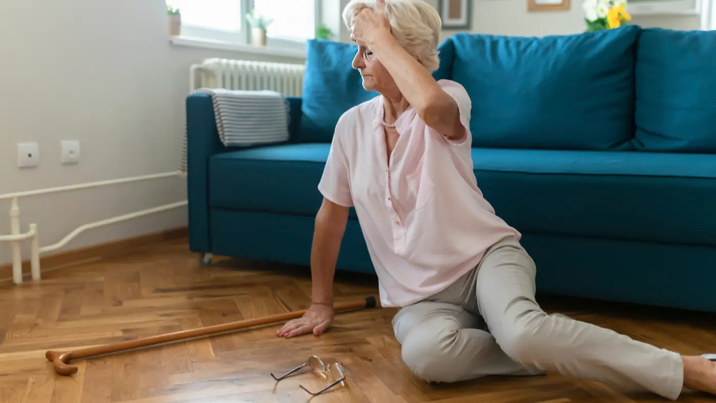 woman after falling with cane and glasses on the floor