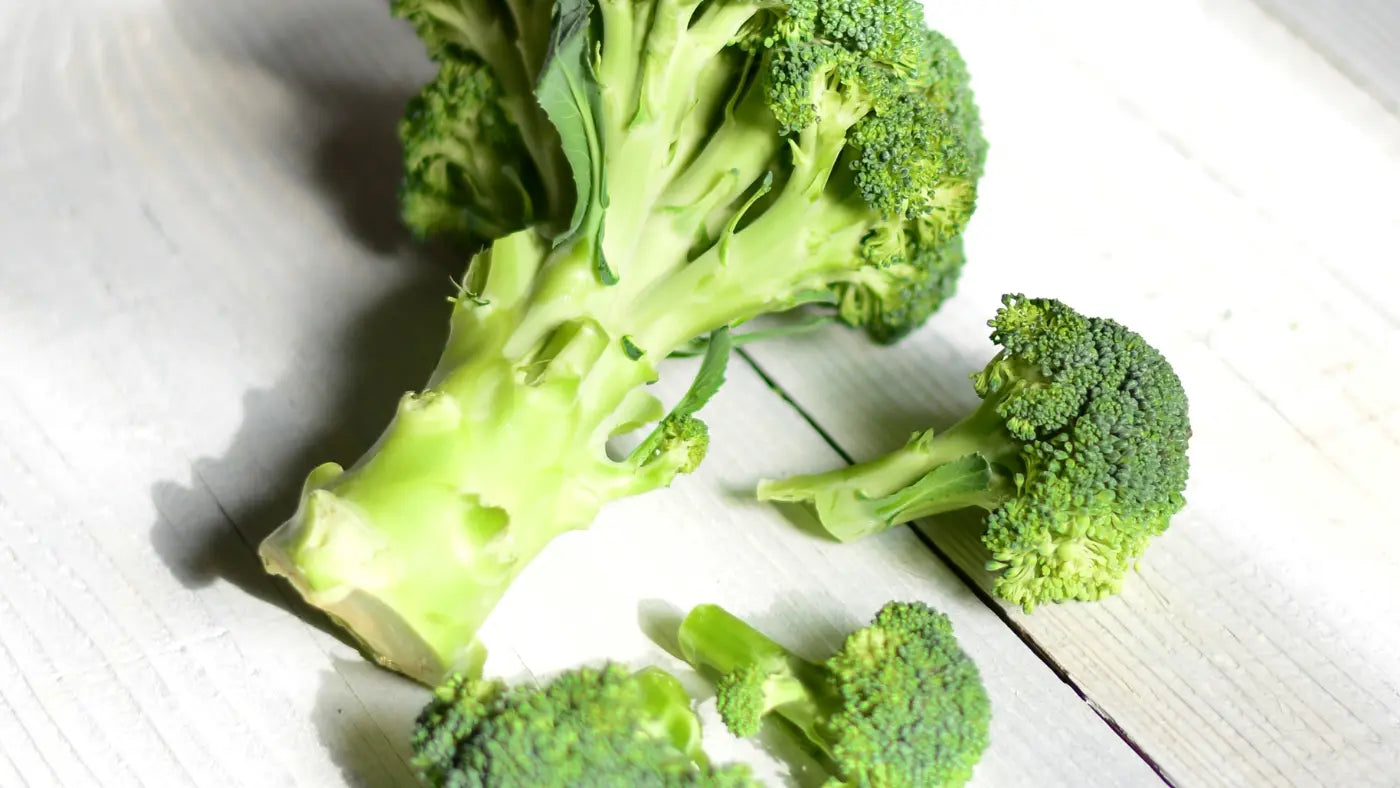 Broccoli florets laying on white background broken up