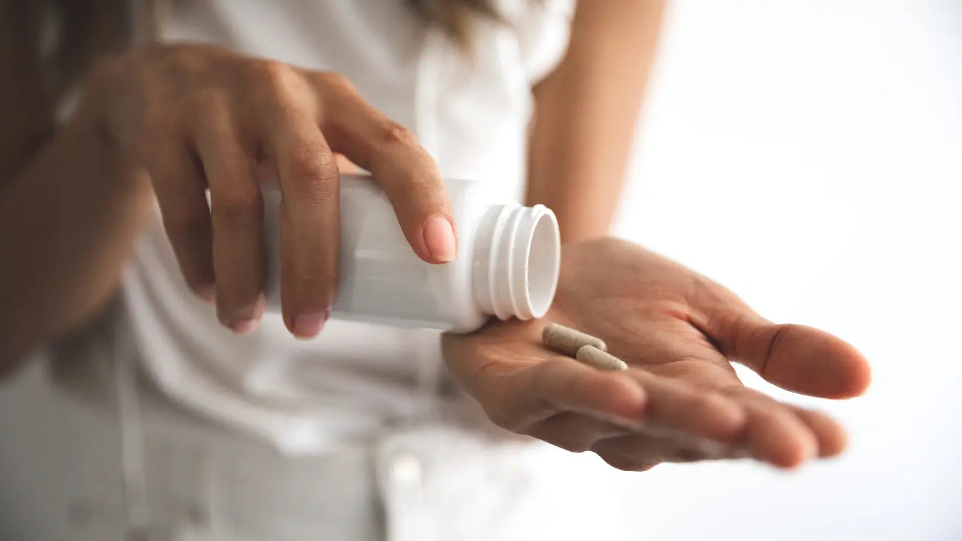 Woman holding supplements in hand