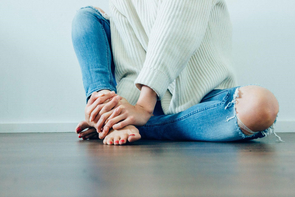 woman-sitting-on-floor-barefoot
