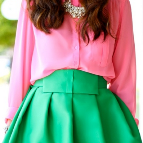 Lady wearing a pink blouse and green pleated skirt
